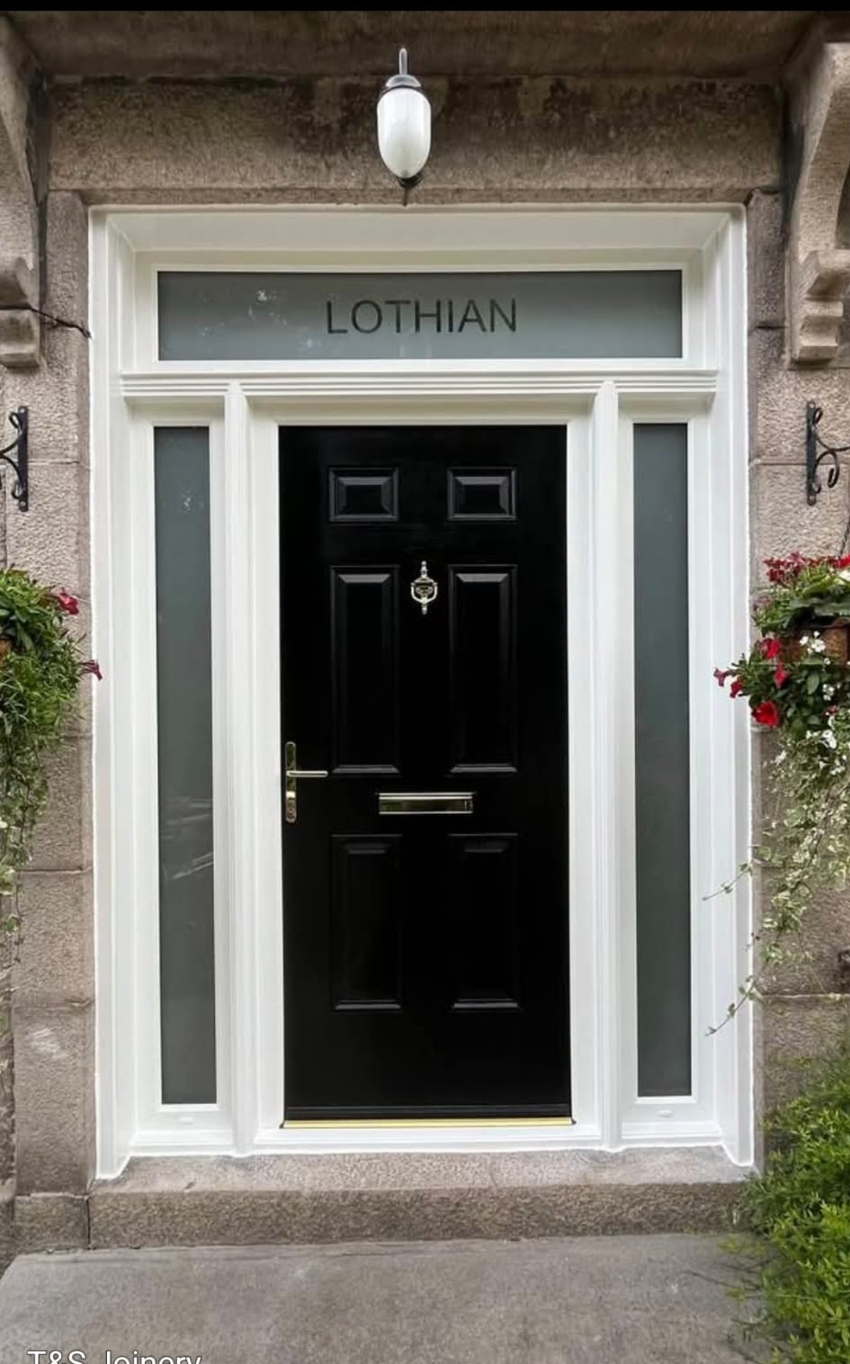 Black composite Lothian-style entrance door installed by ThermaView Scotland in granite stonework