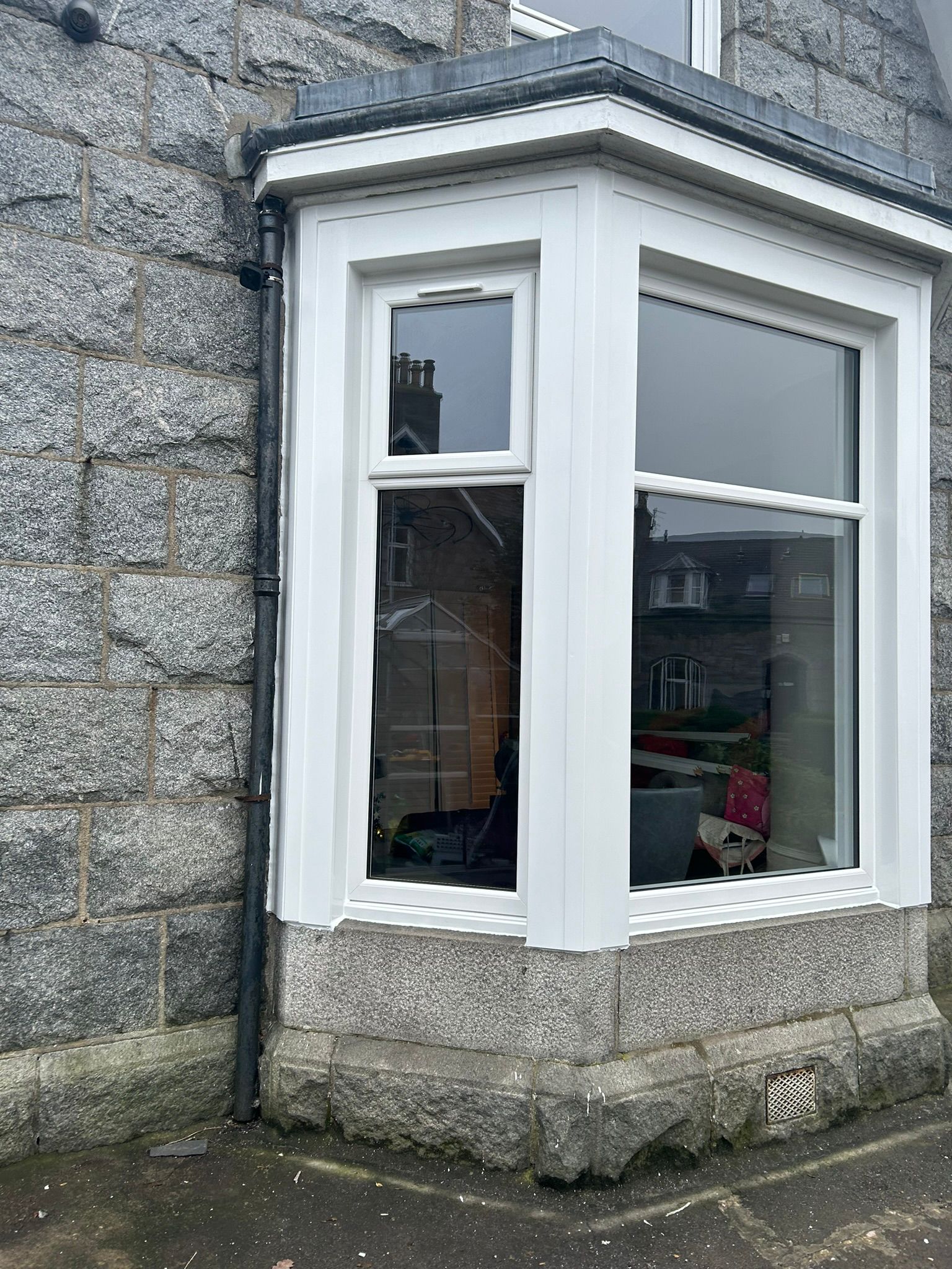 White uPVC tall casement window in sandstone surround